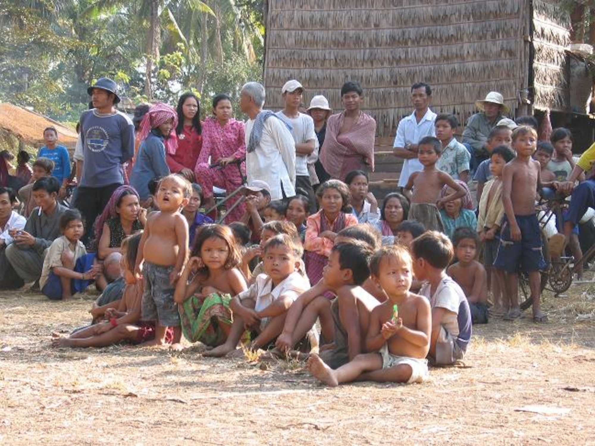 CAMBODIA -- Local Vietnamese children wait for aid, as PACAF Airmen prepare to distribute donated clothing, toys, school kits, hygiene kits, and much more. During the mission, the team screened more than 13,000 patients and treated approximately 3,500 patients. The donated items helped approximately 2,000 children.