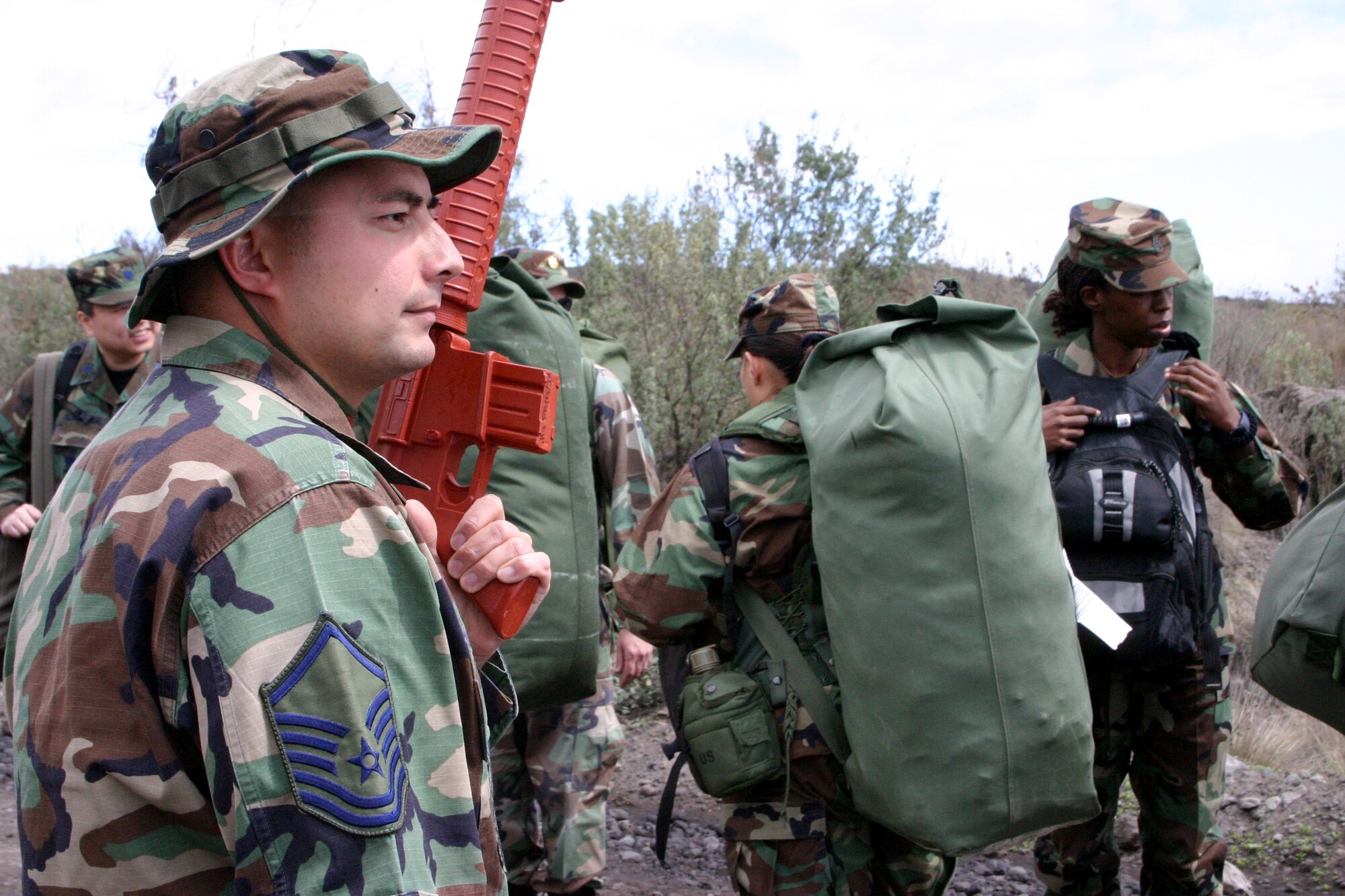 Master Sgt. Daniel Kazumura stands alongside participants in this year's Pacific Joint Legal Exercise on Sunday, March 5, 2006.  The Pacific Air Forces exercise provides legal professionals with realistic deployment training.  Nearly 30 U.S. active duty, Guard and Reserve legal professionals and one Canadian officer endure a week of austere conditions as well as classroom and scenario-driven lessons at the Pohakuloa Training Area, Hawaii. Sergeant Kazumura is the noncommissioned officer in charge of operations and readiness, Pacific Air Forces judge advocate office. (U.S. Air Force photo/Tech. Sgt. Chris Vadnais)
