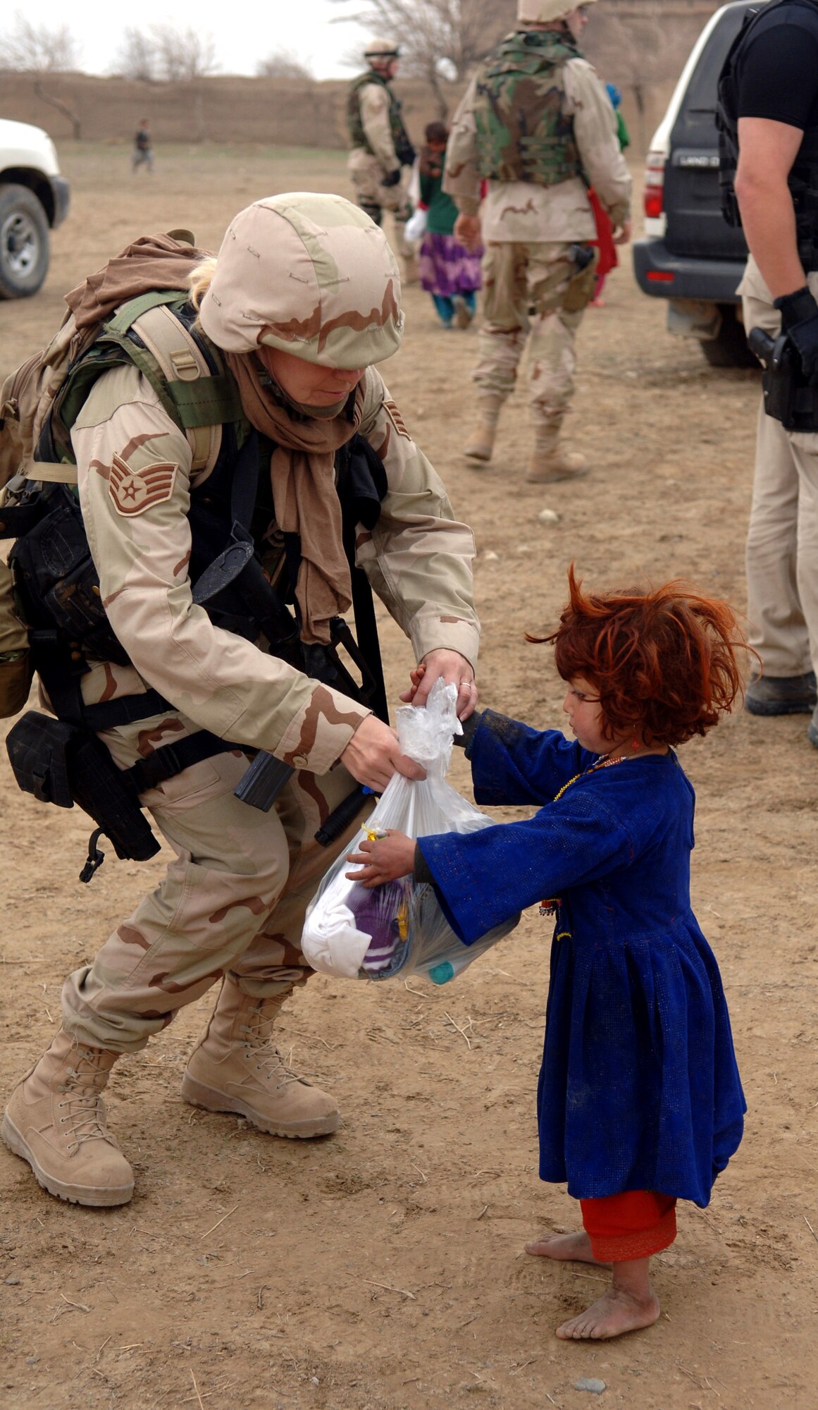 Staff Sgt. Karen Bishop hands clothes to a young girl from the village of Gadia, Afghanistan. Sergeant Bishop is a special tactics analyst assigned to the 455th Expeditionary Special Tactics Squadron at Bagram Air Base, Afghanistan. The Reservist is deployed from the 123rd Special Tactics Squadron at Standiford Field, Louisville, Ky. (U.S. Air Force photo/Staff Sgt. Jennifer Redente) 