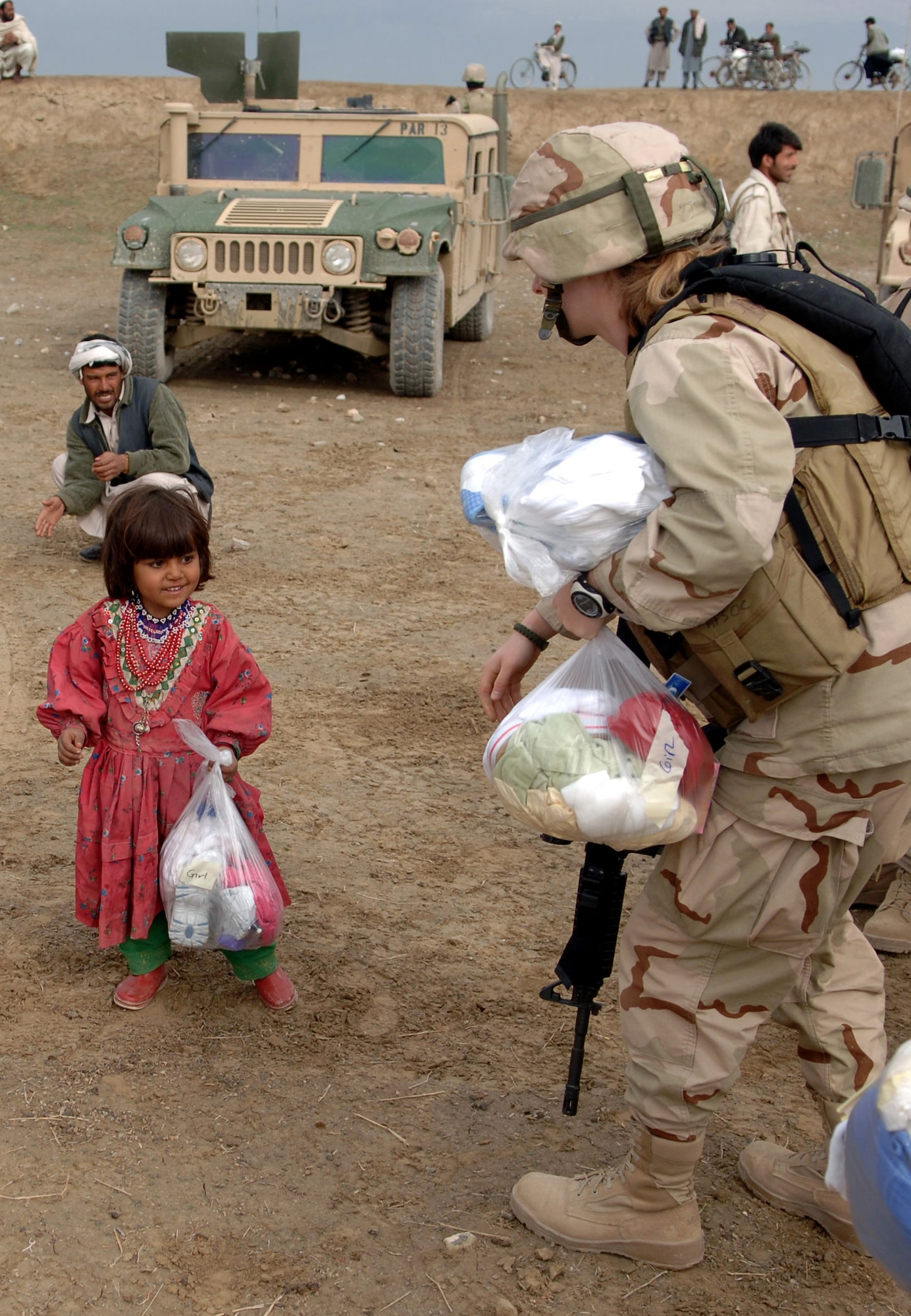 A young girl smiles at 1st Lt. Marcia Frazho after receiving a bag of assorted goods during a recent Adopt-A-Village visit to Gadia in Parwan Province, Afghanistan. Lieutenant Frazho is an intelligence officer assigned to the 455th Expeditionary Special Tactics Squadron at Bagram Air Base, Afghanistan. (U.S. Air Force photo/Staff Sgt. Jennifer Redente) 