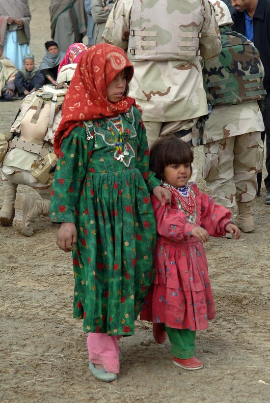 Young girls walk to receive bags of clothes and assorted goods in Parwan Province, Afghanistan. More than 400 bags were recently handed out to the Afghans by Airmen at Bagram Air Base. (U.S. Air Force photo/Staff Sgt. Jennifer Redente) 