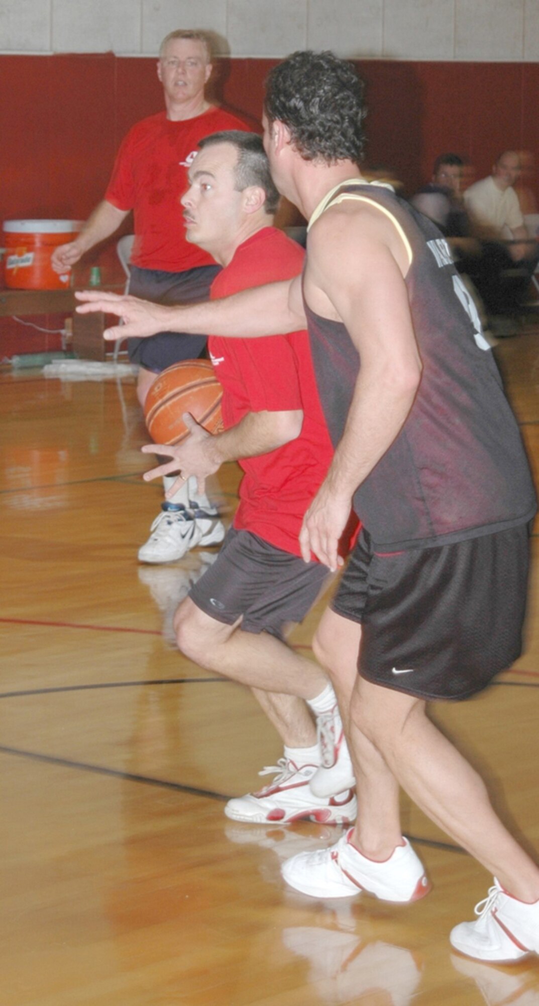 Ralph Ross of the DOD Police drives past Comm's Trent Ward during the championship game of Grissom' Air Reserve Base's annual basketball tournament. Ross and the cops shackled the communicators 72-52 and seized the trophy.