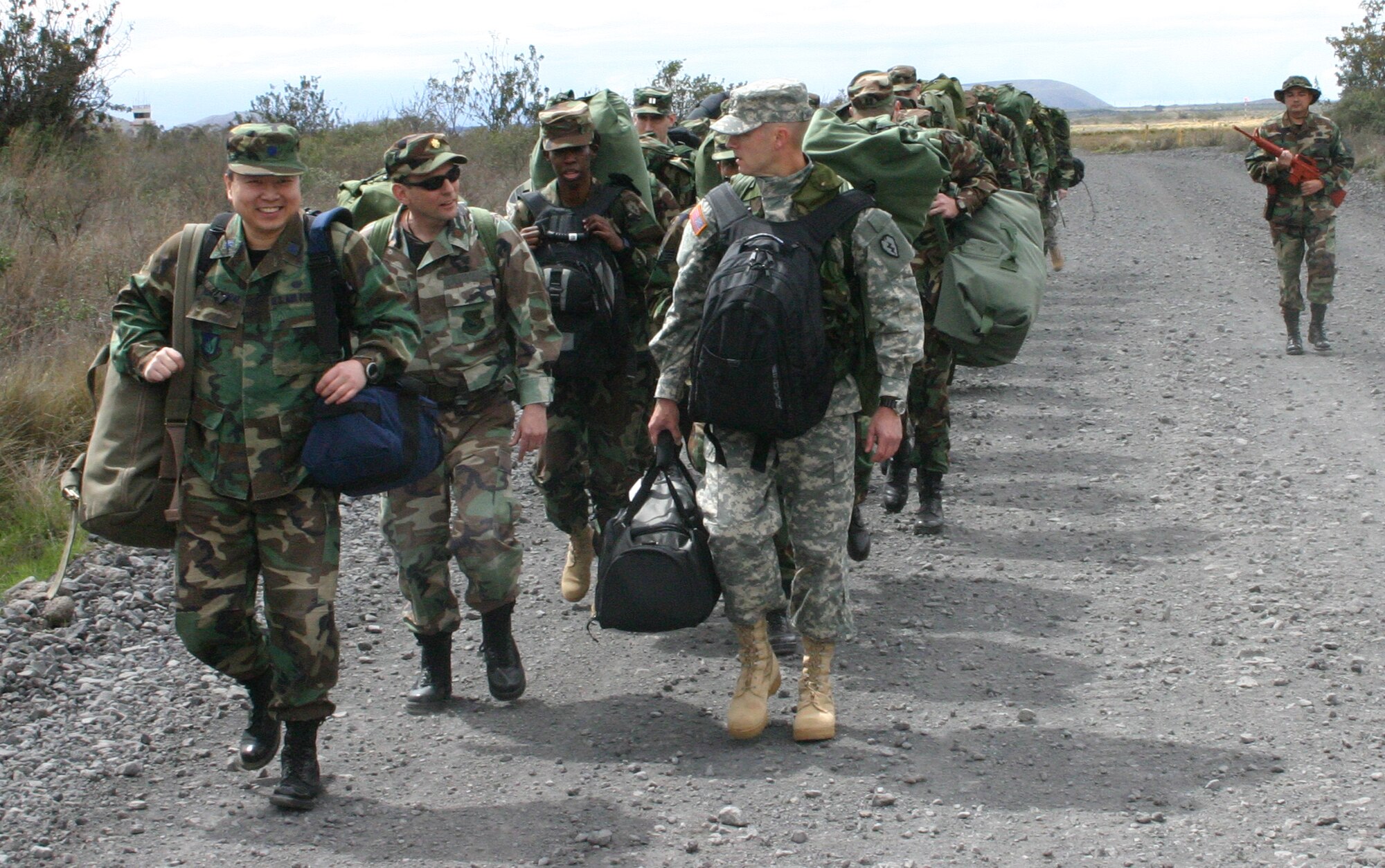 HAWAII -- Master Sgt. Daniel Kazumura, NCOIC of Operations and Readiness, Pacific Air Forces Judge Advocate office, (right) walks alongside the participants in this year’s Pacific Joint Legal Exercise. The PACAF exercise provides legal professionals with realistic deployment training. Nearly 30 U.S. Active Duty, Guard, and Reserve legal professionals and one Canadian officer will endure a week of austere conditions as well as classroom and scenario-driven lessons at the Pohakuloa Training Area on the island of Hawaii.