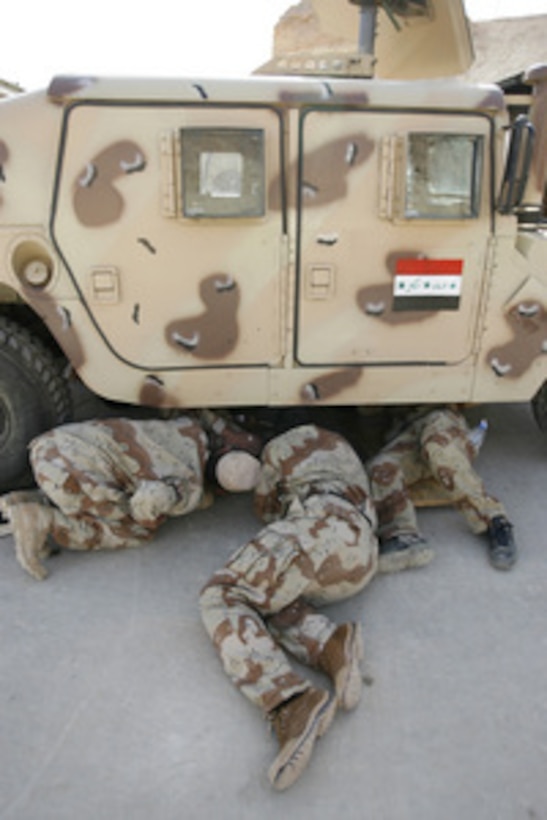 Iraqi army soldiers examine the underside of a Humvee as they learn high-mobility multi-wheeled vehicle maintenance during a class in Al Anbar, Iraq, on March 2, 2006. The Iraqi soldiers from Headquarters Company, 3rd Battalion, 2nd Brigade, are being taught the intricacies of the Humvee by U.S. Marines from the Motor Transport Company, 7th Marine Regiment. 