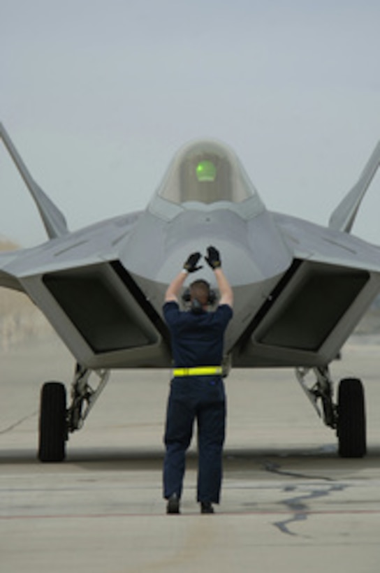An Air Force crew chief directs the pilot of F-22A Raptor aircraft to a parking spot on the ramp after a flight over Davis-Monthan Air Force Base, Ariz., on March 4, 2006. The Raptor is at Davis-Monthan for the Air Forceís 2006 Heritage Conference. 