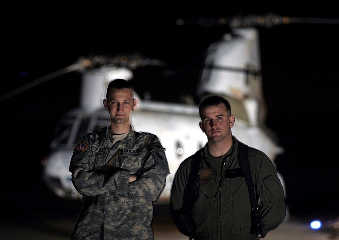 Lance Cpl. Andrew K. Davis (right) stands with his brother, Army Spc. Stuart C. Davis, in front of a CH-46 Sea Knight at Al Asad, Iraq, March 8. The crew chief with Marine Medium Helicopter Squadron 774, Marine Aircraft Group 16, 3rd Marine Aircraft Wing, saw his brother, who is a production control specialist with 2nd Battalion, 224 Aviation Regiment, MAG-16, for the first time in more than a year. The Davis brothers are natives of Mechanicsville, Va.