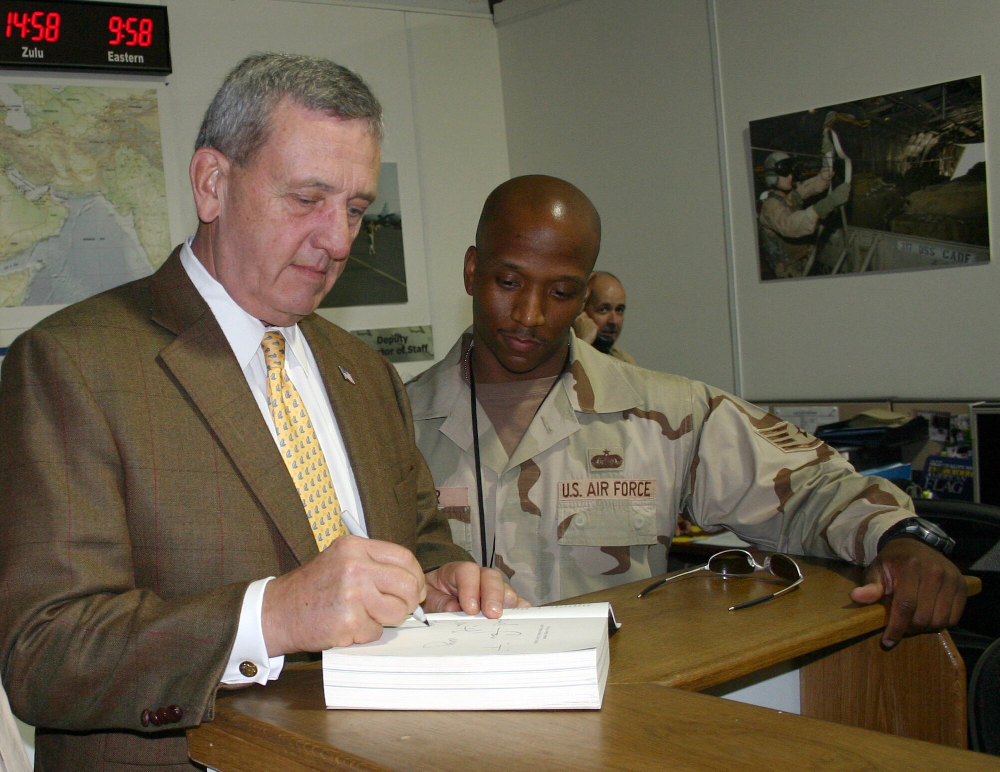 Retired Army Gen. Tommy R. Franks signs his book, "American Soldier," for Staff Sgt. Travares Dozier, enlisted aide for the director of mobility forces at the Combined Air Operations Center. The former U.S. Central Command commander took time to visit with coalition troops during a trip to the Middle East, Wednesday, March 8, 2006. (U.S. Air Force photo/Staff Sgt. Melissa Koskovich)