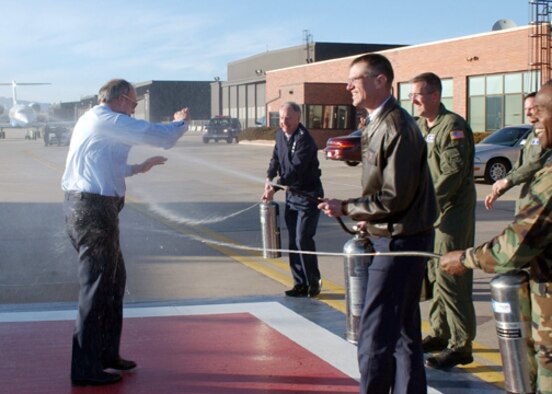 PETERSON AIR FORCE BASE, Colo. -- Lt. Gen. Frank Klotz, Col. Jay Santee, Col. John Hyten, and Col. Jimmy McMillian hose down General Lance W. Lord, Air Force Space Command commander, after his “Fini Flight” here Feb. 27. The Fini Flight is an Air Force tradition of dousing an Airman after his or her final flight with the unit. General Klotz is AFSPC vice commander, Colonel Santee is the 21st Space Wing commander, Colonel Hyten is the 50th Space Wing commander, and Colonel McMillian is the AFSPC commander’s executive officer.