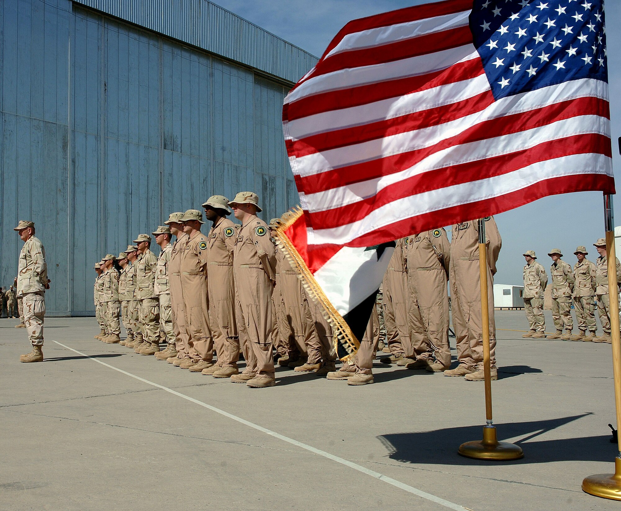 Airmen from the Multinational Security Transition Command Coalition Air Force Transition Team stand in formation during the formal stand-up of New Al Muthana Air Base, Iraq, Tuesday, March 7, 2006. The ceremony recognized the activation of the air base and the Iraqi 23rd Squadron of C-130E Hercules aircraft. The event culminated more than a year of training by U.S. Airmen with the Multinational Security Transition Command Coalition Air Force Transition Team. This is the first post-Saddam Hussein era Iraqi Air Force base and squadron. (U.S. Air Force photo/Master Sgt. Will Ackerman)