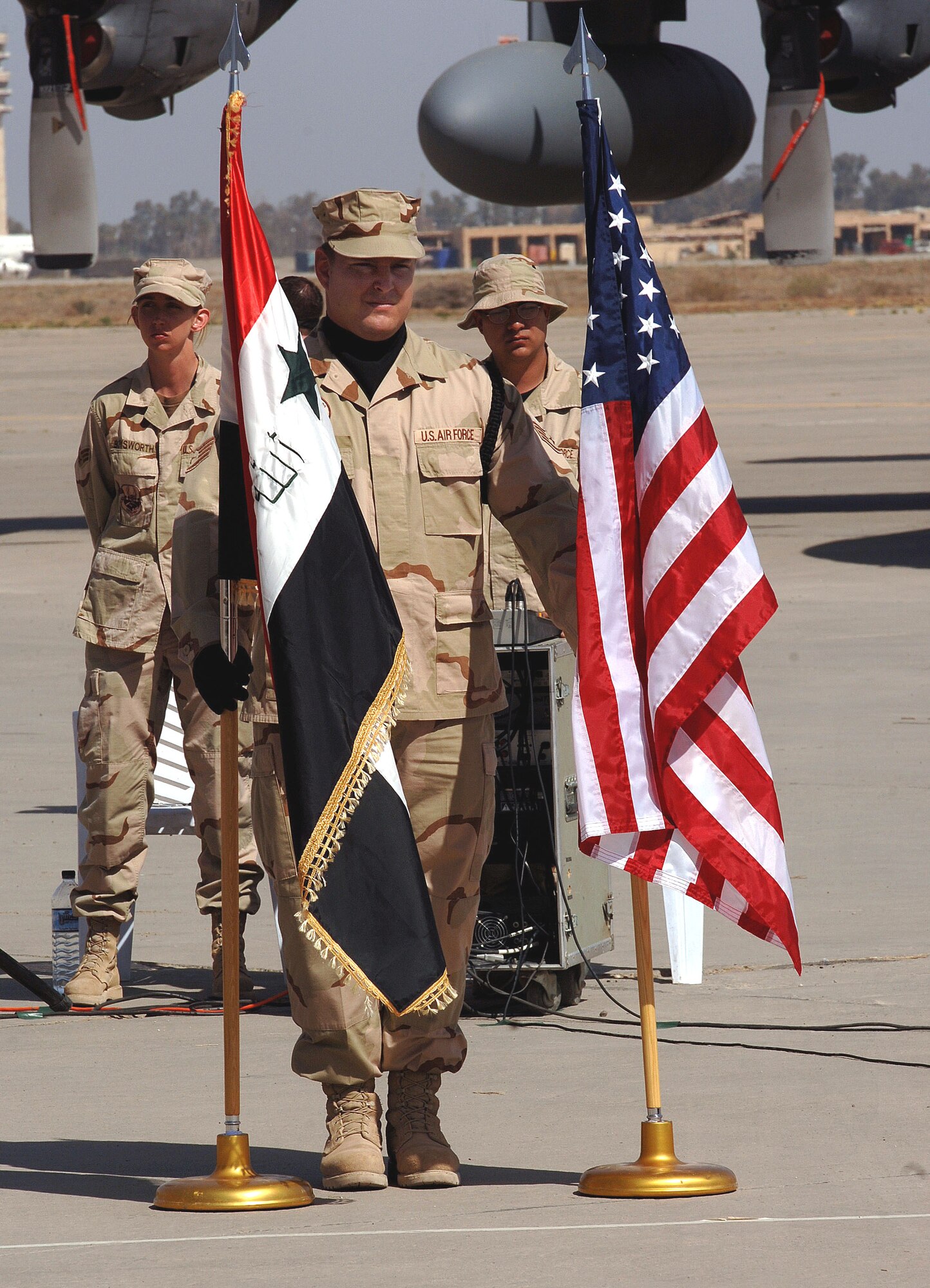 Staff Sgt. William Bennett holds the U.S. and Iraqi flags at the stand-up ceremony for the Iraqi Air Force's 23rd Squadron at New Al Muthana Air Base, Iraq, Tuesday, March 7, 2006. The event culminated more than a year of training by U.S. Airmen with the Multinational Security Transition Command Coalition Air Force Transition Team. This is the first post-Saddam Hussein era Iraqi Air Force base and squadron. Sergeant Bennett is a member of the 447th Air Expeditionary Group honor guard. (U.S. Air Force photo/ Master Sgt. Will Ackerman)