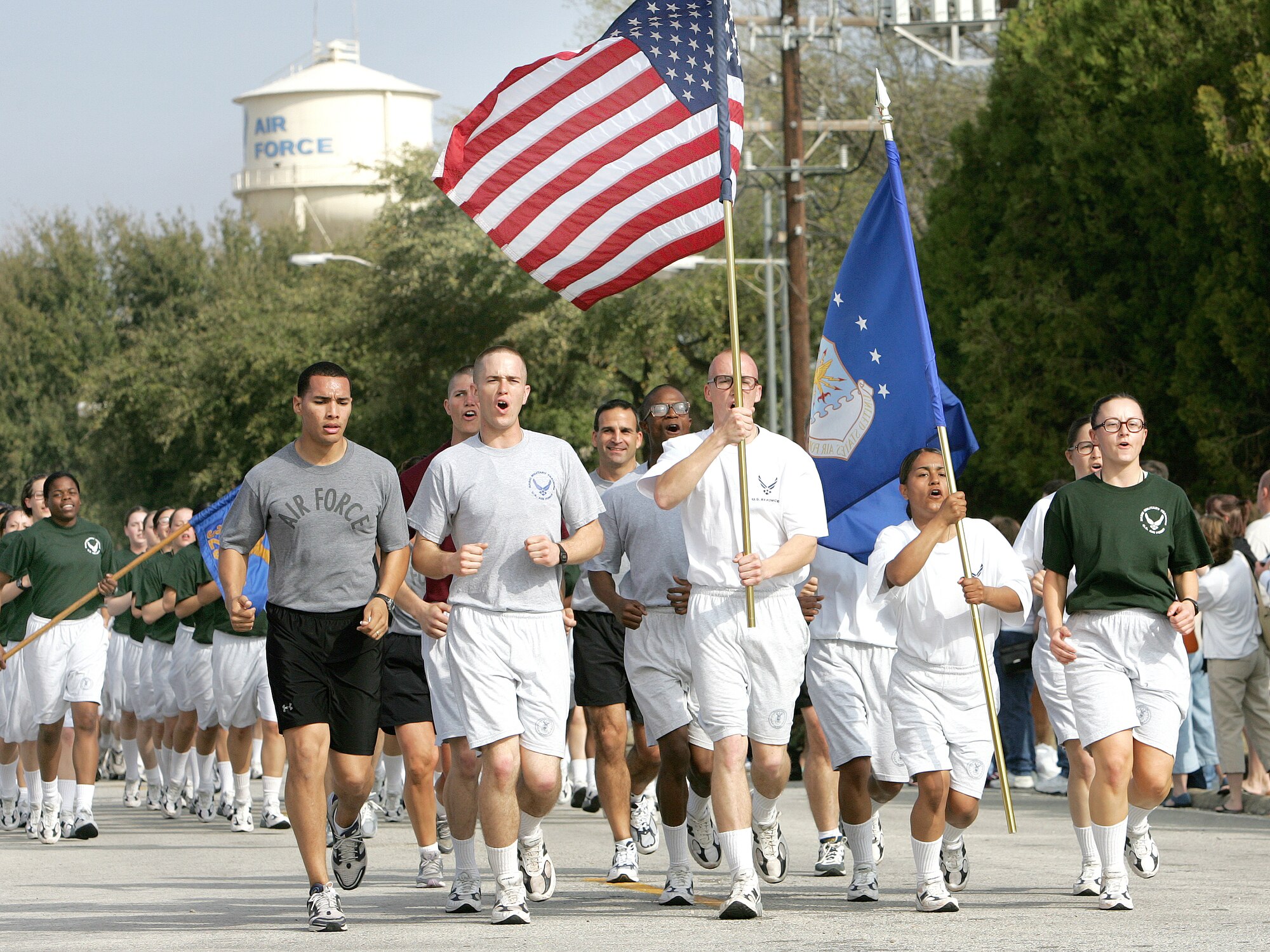 Airman Basic Zachary Zopp, holding the U.S. flag, and Airman Basic Melissa Nash, carrying the Air Force flag, lead the "Airman's Run" Thursday, March 2, 2006, at Lackland Air Force Base, Texas. The two were the week's top athletes in basic military training. Airman Zopp is with the 326th Training Squadron's Flight 214, and Airman Nash is with the squadron's Flight 212. (U.S. Air Force photo/Robbin Cresswell)

