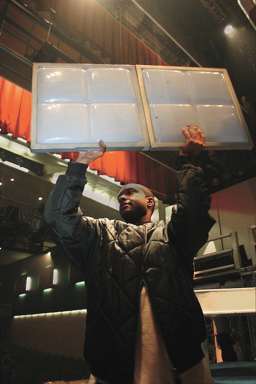 CANNON AIR FORCE BASE, N.M. -- Airman Wardell Wheeler Jr., 27th Services Squadron, pulls down light panels after the Top In Blue show Feb. 16. (U.S. Air Force photo by Janet Taylor-Birkey)