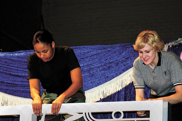 Senior Airman Shawnta Butler, 27th Operation Support Squadron, helps Staff Sgt. Amanda Young, Lackland Air Force Base, build the railing for the upper stage. (U.S. Air Force photo by Janet Taylor-Birkey)