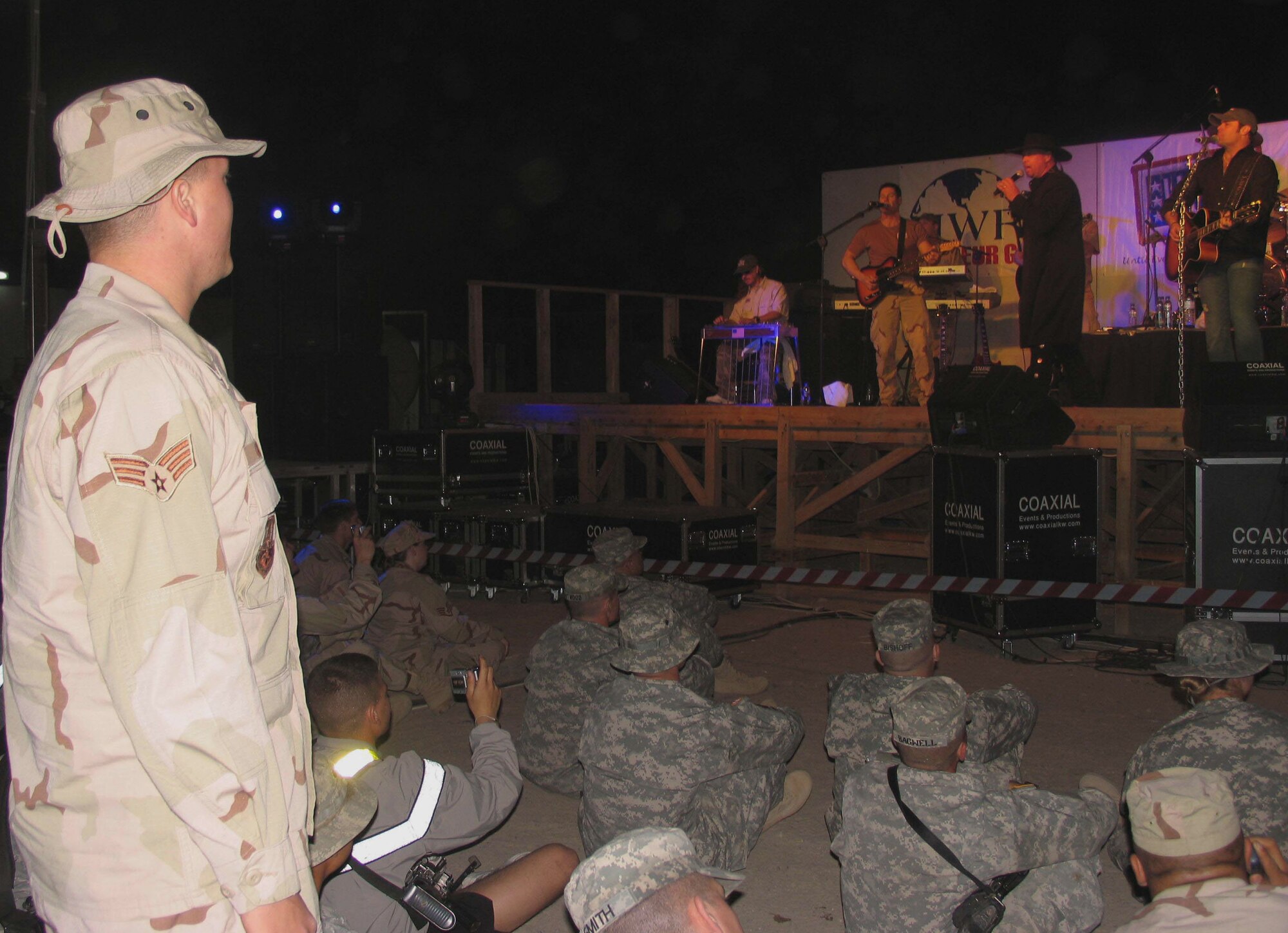 Senior Airman Matthew Gregg sings along at a USO-sponsored concert Wednesday, March 8, 2006, at a deployed location in Southwest Asia. The country duo Montgomery Gentry performed for more than 2,500 deployed servicemembers. Airman Gregg is with the 386th Expeditionary Logistics Readiness Squadron. (U.S. Air Force photo/Staff Sgt. Jasmine Reif)