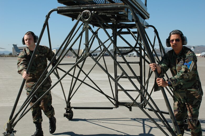 2nd Lt. Wesley Hayne 60th Aircraft Maintenance Squadron assistant officer in charge, and Master Sgt. Edmund Diaz, 60th Aircraft Maintenance Squadron production supervisor, properly push a B5 stand to an awaiting C-5. (U.S. Air Force photo by Staff Sgt. Matt McGovern) 