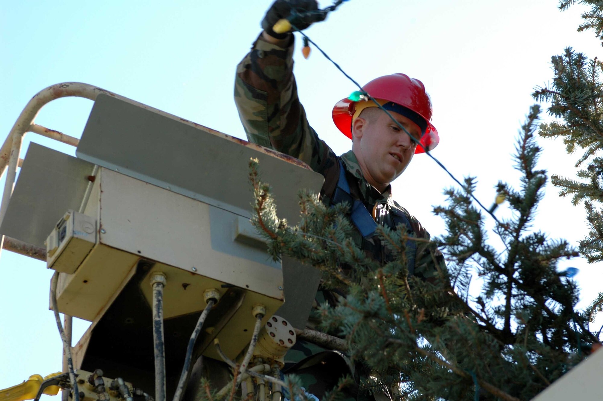 Senior Airman Ricky Brown, 60th Civil Engineer Squadron electrical distribution, wears a safety harness, a hardhat and gloves to remove Christmas lights on corner of Ragsdale Street and Travis Avenue Wednesday. (U.S. Air Force photo by Staff Sgt. Matt McGovern) 