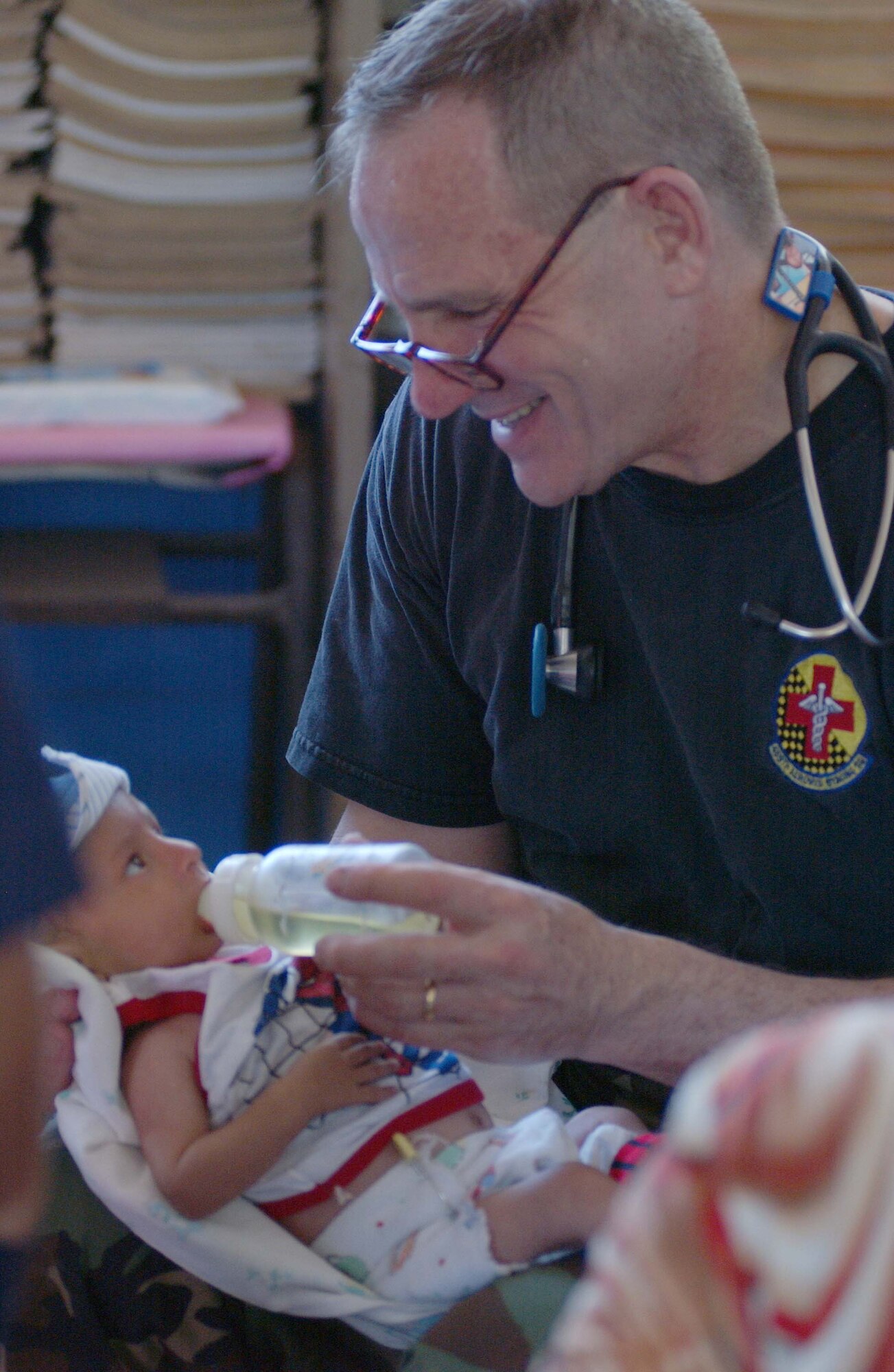 Lt. Col. (Dr.) Will Mosier, Air Force Reserve 459th Aeromedical Staging Squadron out of Andrews Air Force Base, holds a small malnorished El Salvadorian three-month-old baby.  Mosier provided medical counseling to the mother and milk for her child.