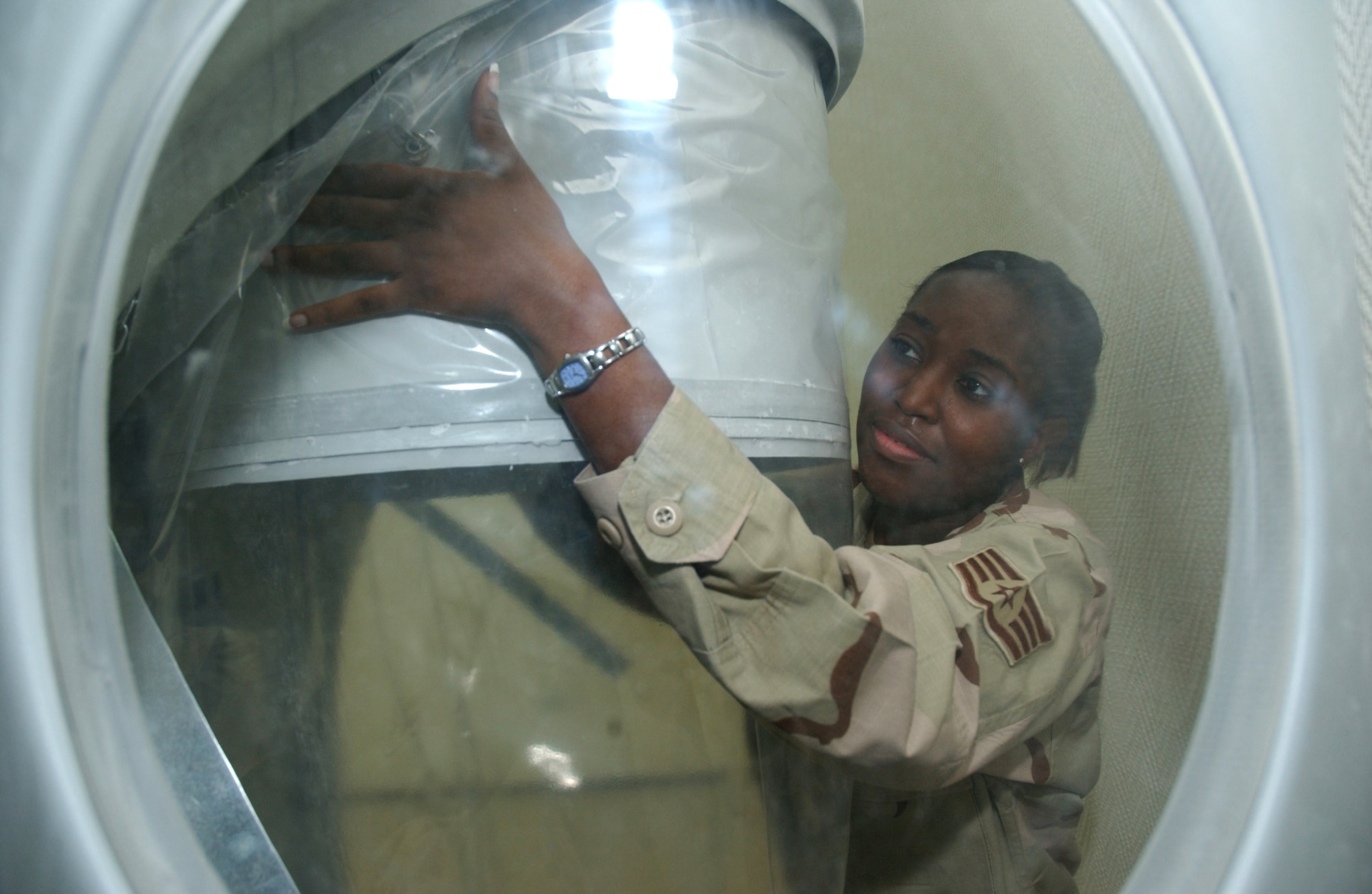 Staff Sgt. Cassandra Ali replaces a shredder bag at the industrial shredder at a deployed location in Southwest Asia. Sergeant Ali is the 379th Expeditionary Communications Squadron base records manager. (U.S. Air Force photo/Airman 1st Class Anthony Nelson Jr.)

