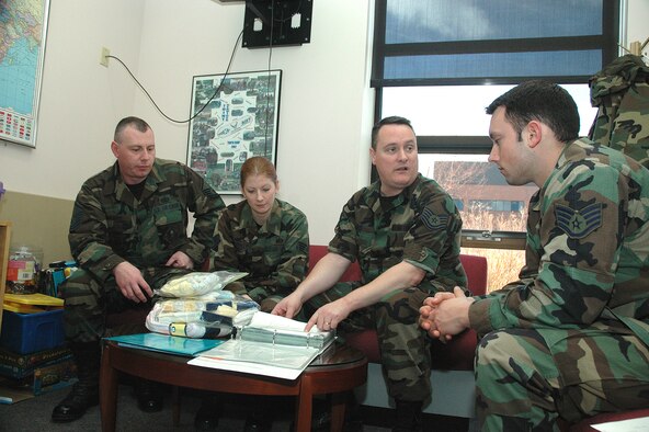 YOUNGSTOWN AIR RESERVE STATION, Ohio - From left, Air Force Reserve Family Readiness Technicians from the 910th Airlift Wing, Master Sgt. Tom Ruskin, Staff Sgt. Marcy Yerkey and Tech. Sgt. Perry Foos, go through the Bundles for Babies training with expectant father, Staff Sgt. Jamie Purola of the 910th Communications Flight here.  The Bundles for Babies program is sponsored by the Air Force Aid Society to provide parenting skills training to expectant parents.  Attendees also receive a gift pack like the one displayed on the table. (U.S. Air Force Photo by Tech. Sgt. Ken Sloat)