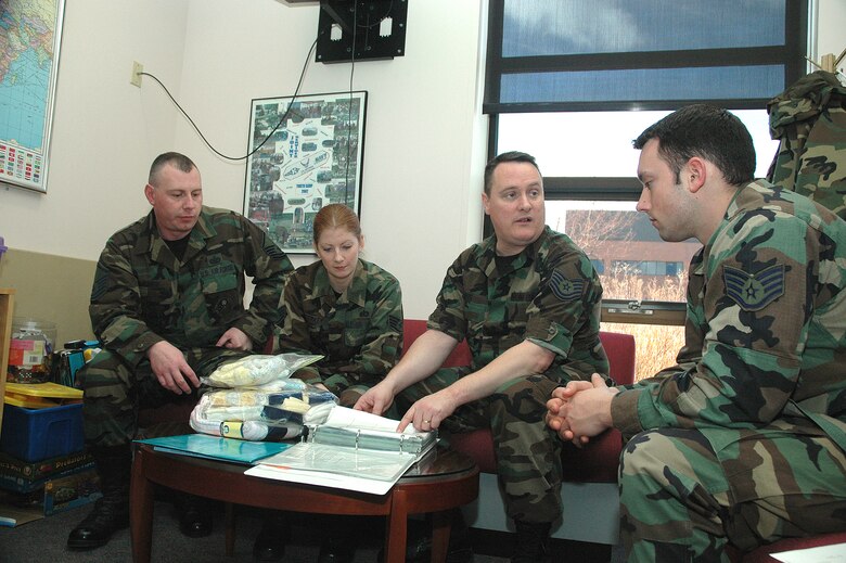 YOUNGSTOWN AIR RESERVE STATION, Ohio - From left, Air Force Reserve Family Readiness Technicians from the 910th Airlift Wing, Master Sgt. Tom Ruskin, Staff Sgt. Marcy Yerkey and Tech. Sgt. Perry Foos, go through the Bundles for Babies training with expectant father, Staff Sgt. Jamie Purola of the 910th Communications Flight here.  The Bundles for Babies program is sponsored by the Air Force Aid Society to provide parenting skills training to expectant parents.  Attendees also receive a gift pack like the one displayed on the table. (U.S. Air Force Photo by Tech. Sgt. Ken Sloat)