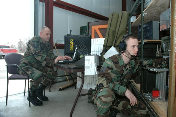 YOUNGSTOWN AIR RESERVE STATION, Ohio - Air Force Reserve Master Sgt. Tim Henderson assists Air Force Reserve Tech. Sgt. Stephen Edie during a preventive maintenance inspection of the Aerial Spray Communications Mobility Bin here.  The  910th Communications Flight deployed to Duke Field, Fla. with the aerial spray team to provide support during spraying operations after Hurricane Katrina.  (U S. Air Force Photo by Tech. Sgt. Ken Sloat) 