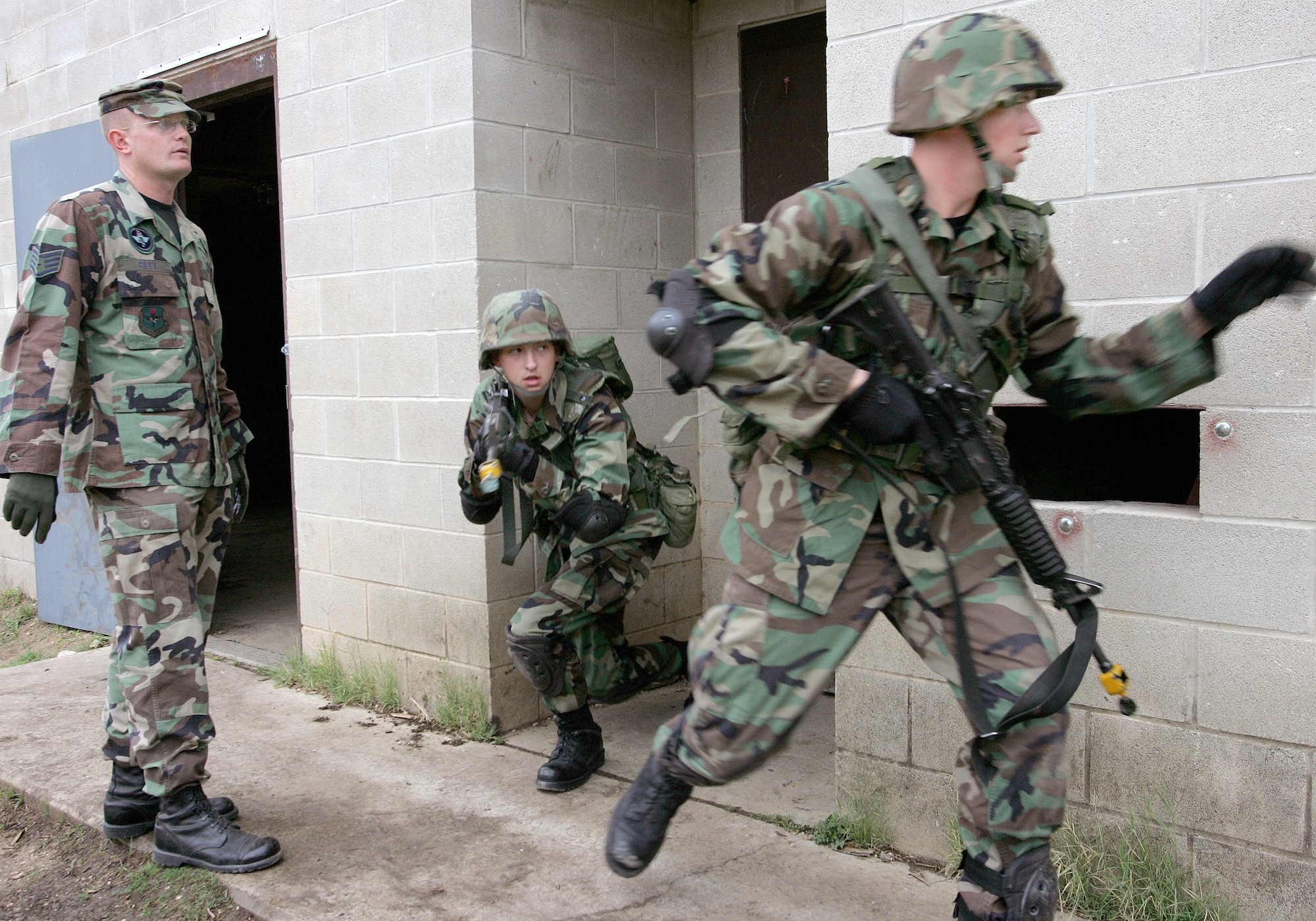 Staff Sgt. Adam Riley observes students leaving a building during urban training at Camp Bullis, Texas, Tuesday, March 7, 2006. Sergeant Riley is an instructor with the 343rd Training Squadron at Lackland Air Force Base, Texas. (U.S. Air Force photo/Robbin Cresswell) 



                                