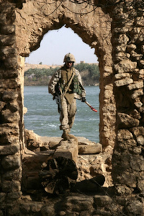 Marine Cpl. Robert Houser searches a stone aqueduct for weapons caches in Baghdaddi, Iraq, on March 1, 2006. Houser is assigned to Charlie Company, Combat Engineer Battalion. 