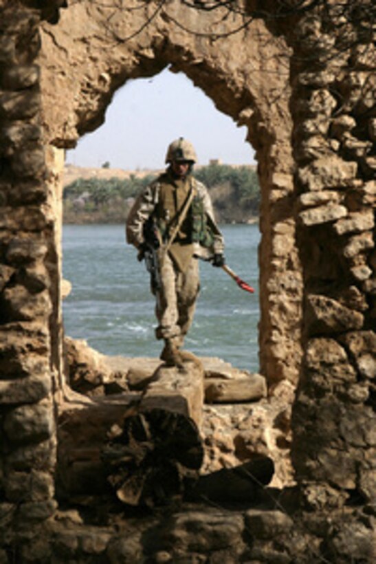 Marine Cpl. Robert Houser searches a stone aqueduct for weapons caches in Baghdaddi, Iraq, on March 1, 2006. Houser is assigned to Charlie Company, Combat Engineer Battalion. 
