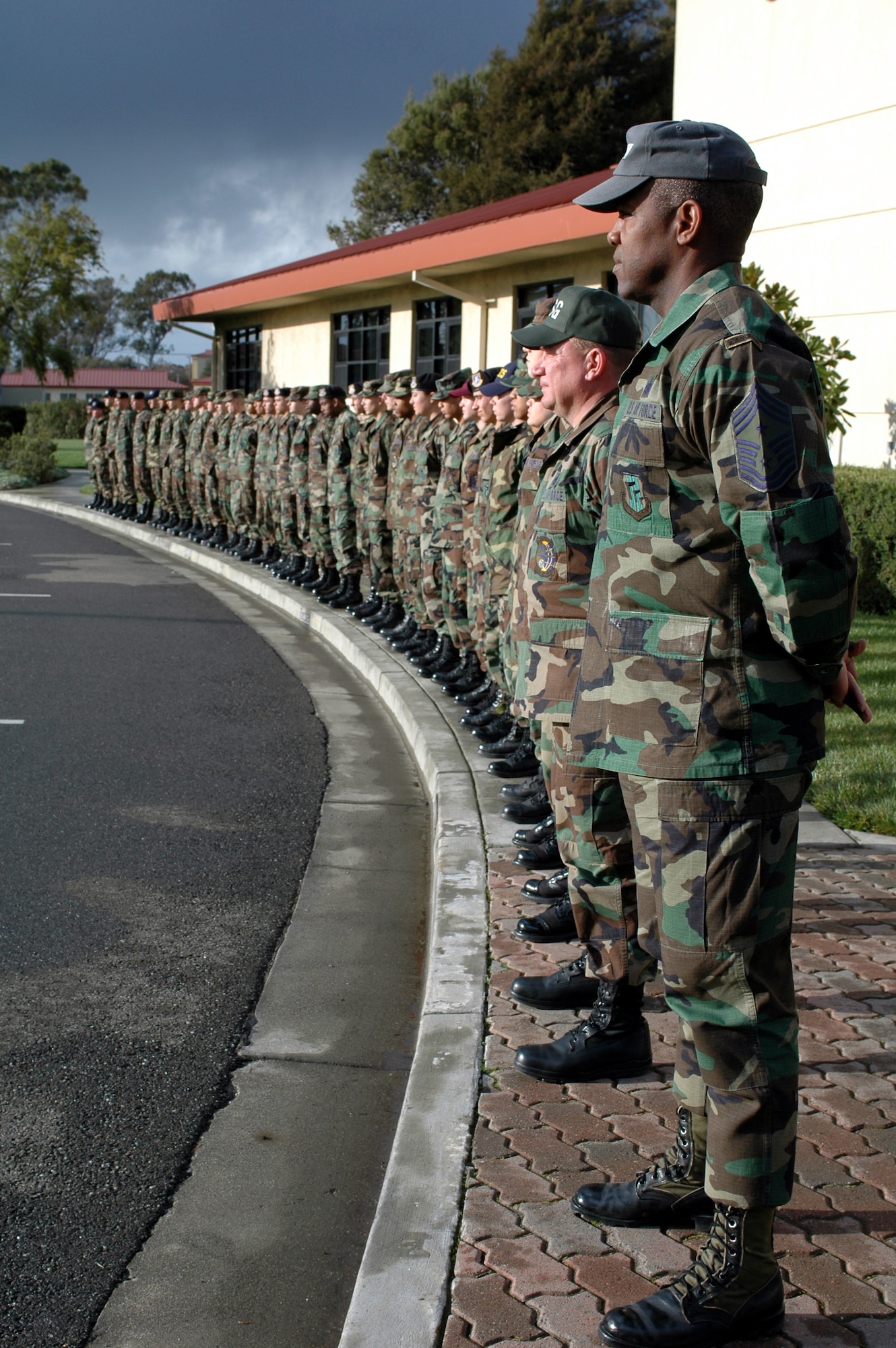 Chief Master Sgt. Brye McMillion stands in parade rest with first-term Airmen before a retreat ceremony at Bldg. 51. (U.S. Air Force photo by Staff Sgt. Matt McGovern)
