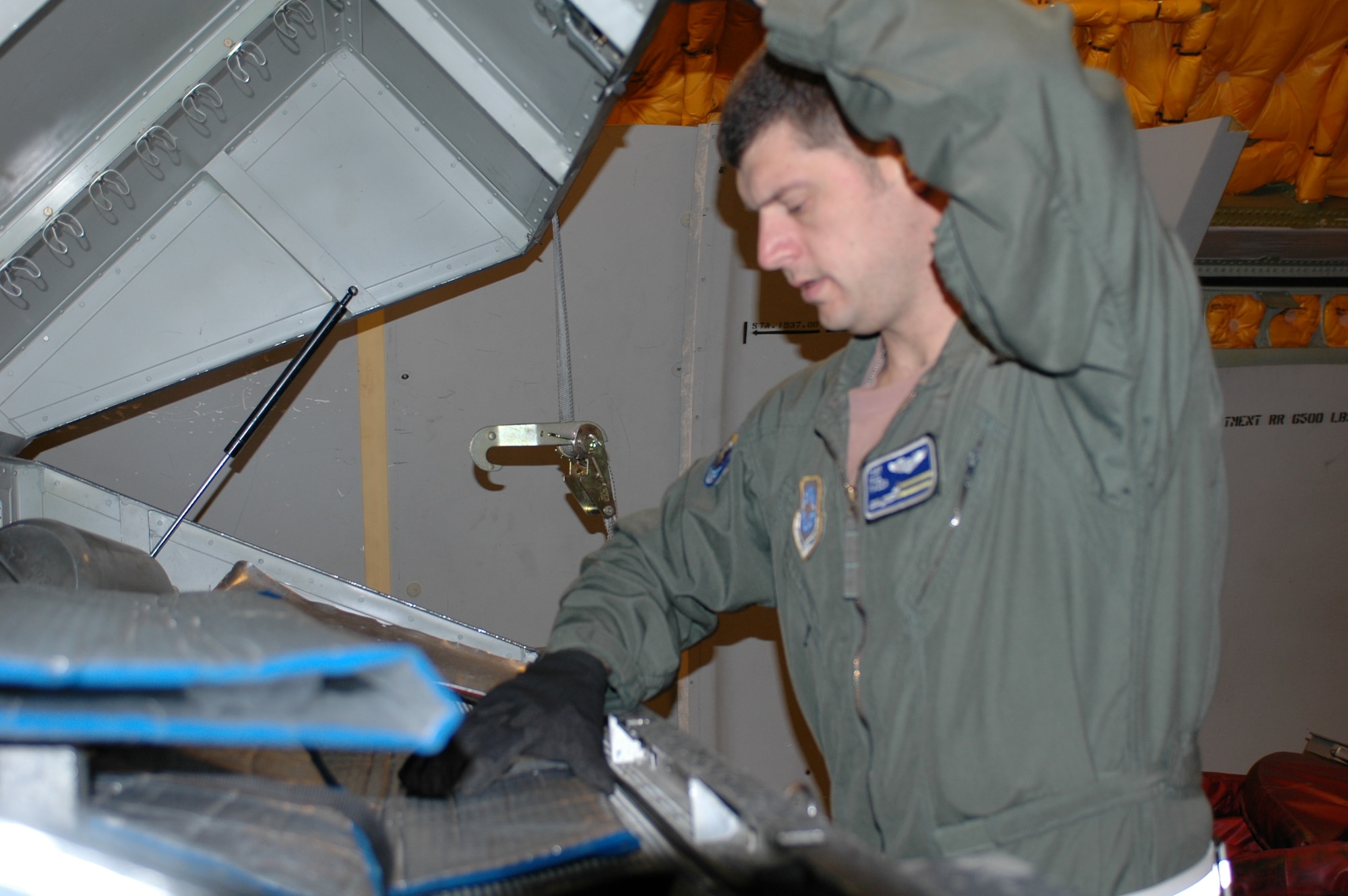 Tech. Sgt. Paul Piazza, 6th Air Refueling Squadron  boom operator instructor, checks safety equipment prior to takeoff. Boom operators must ensure that adequate safety equipment and passenger comfort items are on board the aircraft and instructs any and all passengers how to use emergency equipment and emergency procedures. (U.S. Air Force photo by Staff Sgt. Candy Knight)