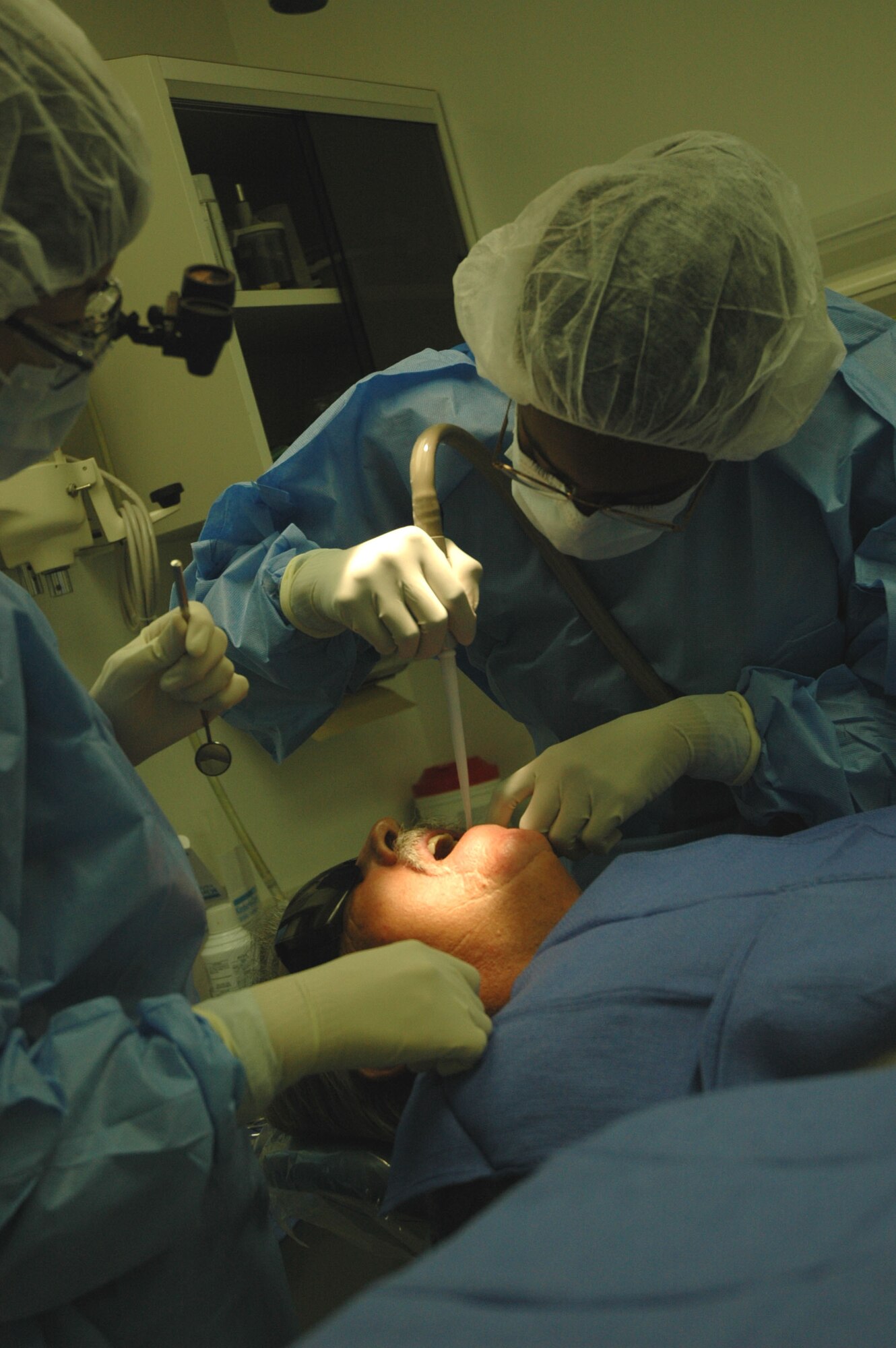 Capt. (Dr.) LiKuei Hung administers suction to a patient during an extraction Monday, March 6, 2006, at Barksdale Air Force Base, La. Doctor Hung is assigned to the 2nd Dental Squadron. (U.S. Air Force photo Staff Sgt. Jeremy Larlee)