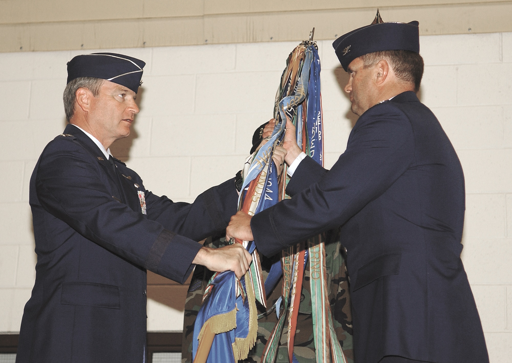 CANNON AIR FORCE BASE, N.M. -- Lt. Gen. Randall Schmidt, 12th Air Force commander, presents Col. Scott West the 27th Fighter Wing guidon in a change of command ceremony Monday in Hangar 208. Colonel West is the former vice commander of the 52nd Fighter Wing at Spangdahlem Air Base, Germany and is a command pilot with more than 2,400 flying hours.