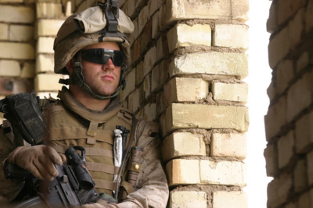 A U.S. Marine stands guard in an abandoned house in Fallujah, Iraq, on March 2, 2006. Marines from the 1st Squad, 3rd Platoon, 2nd Battalion, 6th Marine Regiment, Regimental Combat Team 5 are using the house as a patrol base from which to operate. 