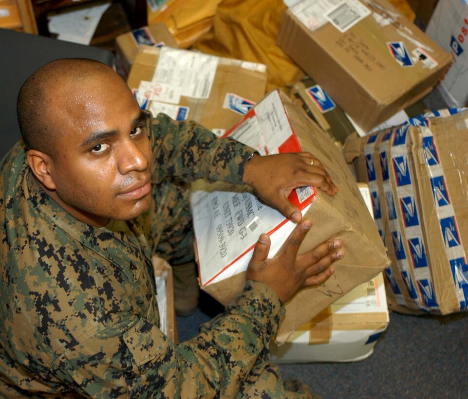 MARINE CORPS BASE CAMP LEJEUNE, N.C.--Lance Cpl. Lawrence L. Davis, II MHG mail/publications clerk here, swims through a sea of mail March 10.  Since the redeployment of more than half of the II MEF, Davis and his fellow postal clerks are working overtime to tackle the surge of incoming parcels origionally sent to Iraq.  Davis reminds all II MHG Marines, "The mail here is all piled up."  Mail call, which is normally a one hour event, is now an ongoing process for II MHG.