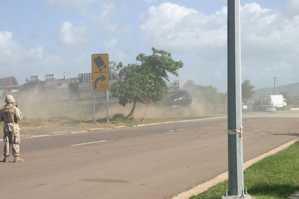 A Landing Craft Air Cushioned kicks up some dust as it comes off the shore, crosses the street and manuevers into an open field in Townsville, Australia, March 13 during the start of sustainment training exercises in the area. The LCAC is transporting Marines from the Battalion Landing Team 1st Battalion, 4th Marine Regiment, 11th Marine Expeditionary Unit, (Special Operations Capable) Camp Pendleton, Calif., who are on a routine six-month deployment through the Western Pacific Ocean and Persian Gulf.