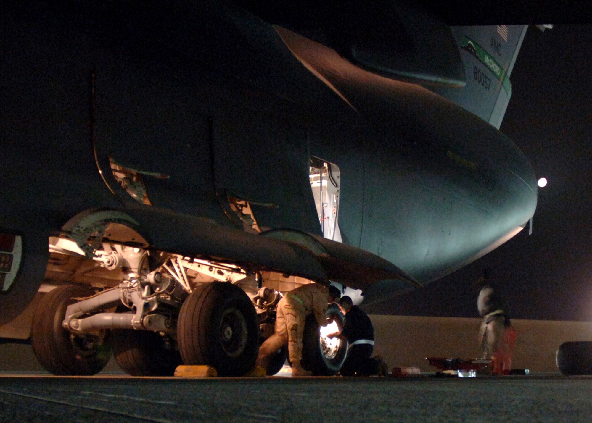 Crewmembers from the 817th Expeditionary Airlift Squadron change a tire on a C-17 Globemaster III at a deployed location in Southwest Asia on Sunday, Mar. 12, 2006. The aircraft is from McChord Air Force Base, Wash. (U.S. Air Force photo/Staff Sgt. Joshua Strang) 