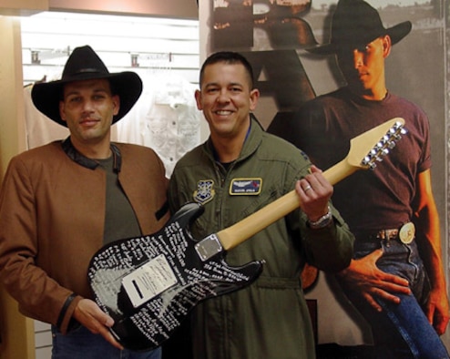 ONIZUKA AIR FORCE STATION, Calif. — Capt. Manuel Ayala, with the 21st Space Operations Squadron here, recently signed “America’s Guitar” at the Moffett Federal Airfield Navy Exchange in Sunnyvale, Calif. The guitar came to Moffett Airfield via country music artist Raymond Harris, who is touring military installations and collecting signatures on the guitar from members of the armed forces and their families. Each military installation Mr. Harris visits will have a guitar named after it.