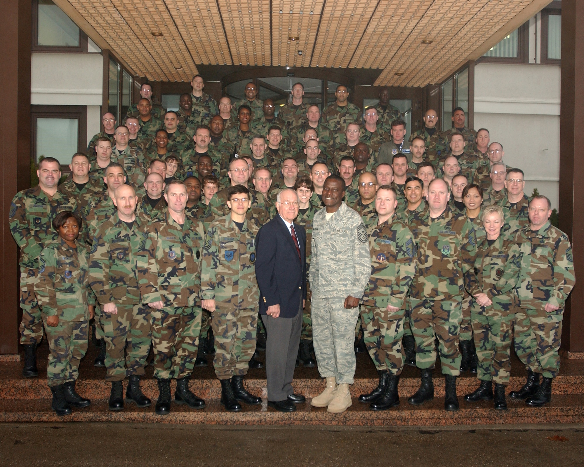 Retired Chief Master Sgt. of the Air Force Sam E. Parish (center wearing suit) stands with U.S. Air Forces in Europe Command Chief Master Sgt. Gary G. Coleman and Airmen attending the USAFE 2006 Chiefs’ Orientation held at Ramstein. (U.S. Air Force photo by Airman Julianne Trulson)