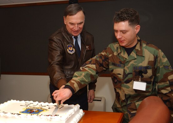 RAMSTEIN AIR BASE, Germany (USAFENS) -- Gen. Tom Hobbins and Airman 1st Class Buddy Rodgers cut a cake Jan. 19 in celebration of U.S. Air Forces in Europe’s 64th Anniversary. Traditionally, Airmen with the longest time on active duty and the least time on active duty are selected for the honor. General Hobbins is the USAFE commander and began his Air Force career December 1969, while Airman Rodgers, a graphics journeyman assigned to USAFE Headquarters, entered the Air Force in December 2003. (Digitally altered photo by Staff Sgt. Rasheen Douglas)