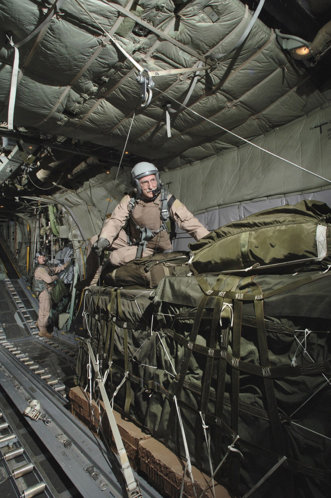 Senior Master Sgt. Ted Poplarchik rigs a second group of containerized delivery system pallets for an operational airdrop re-supply mission to the second of three forward operating bases Thursday, March 9, 2006.  Sergeant Poplarchik is with the 144th Airlift Squadron, Kulis Air National Guard Base, Alaska and deployed to the 774th Expeditionary Airlift Squadron, Bagram Air Base, Afghanistan.  (U.S. Air Force photo/Master Sgt. Lance Cheung)