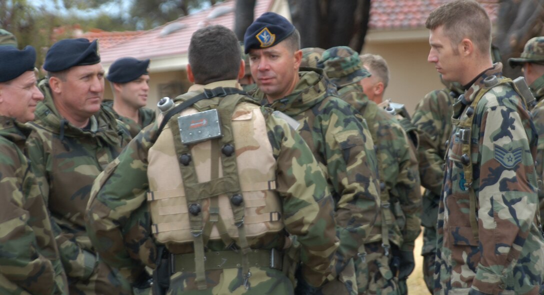 Master Sgt. Kevin Perlak, 944th Security Forces Squadron, discusses tactics as the squad prepares to conduct a building search exercise in base housing March 11. The SFS members searched for enemy forces who had embedded themselves in a local village to use as their headquarters for continual attacks on key war-making capabilities. (U.S. Air Force Reserve photo by Tech. Sgt. Barbara Plante)