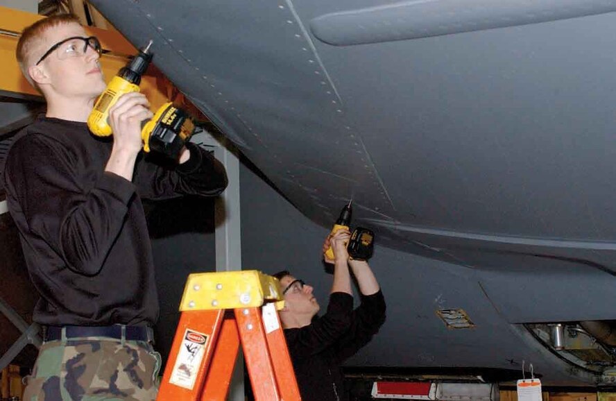 Senior Airman Chris Daniels and Senior Airman Nicholas Labreck, 319th Maintenance Squadron, replace a panel on the wing of a KC-135 during a periodic inspection.