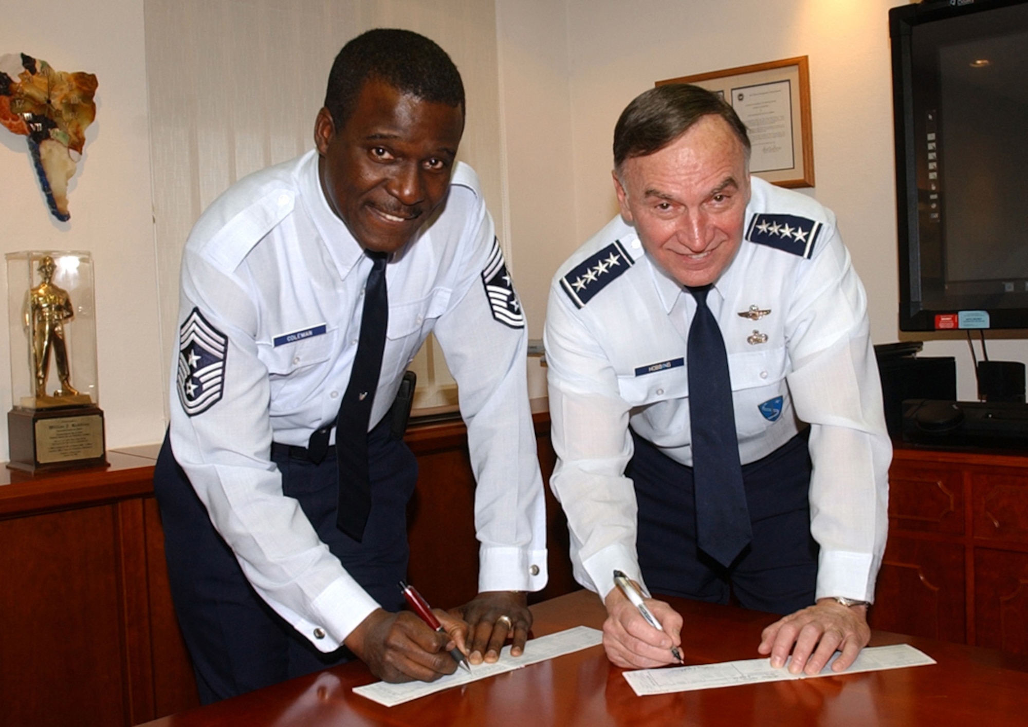 RAMSTEIN AIR BASE, Germany (USAFENS) -- Gen. Tom Hobbins, U.S. Air Forces in Europe commander, and Chief Master Sgt. Gary Coleman, USAFE command chief master sergeant, signed Air Force Assistance Fund forms here recently. This year's Air Force Assistance Fund "Commitment to Caring" campaign, from Feb. 13 to May 5, will provide Airmen the opportunity to contribute to any of the four official Air Force charitable organizations. (Photo by Master Sgt. David Underwood)