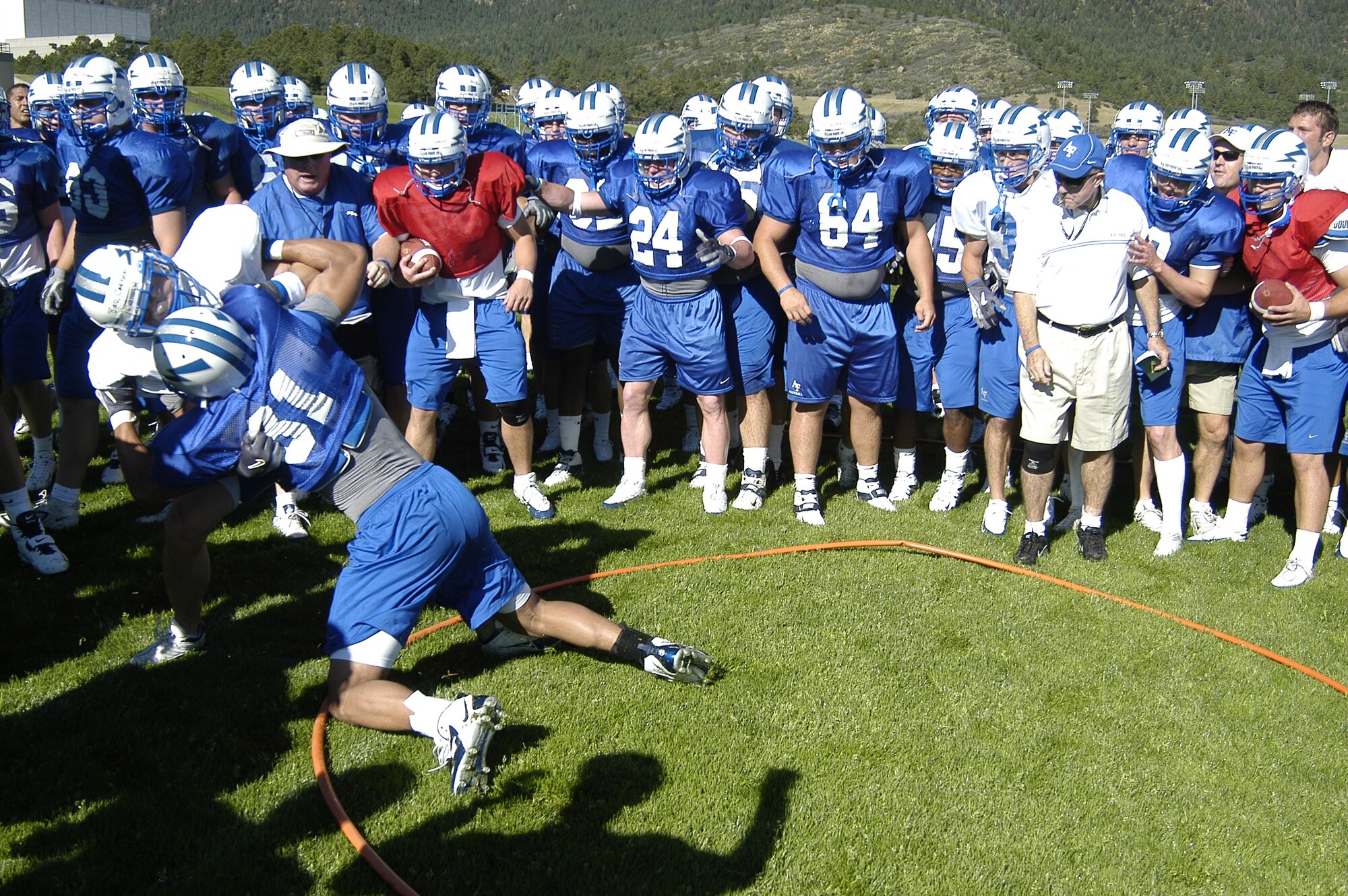 Falcons Head Coach Fisher DeBerry and Falcon players watch the end of a "toughness drill" during practice last season. During the drill, two players try to block each other outside of a small circle for bragging rights. (U.S. Air Force photo/John Van Winkle) 

