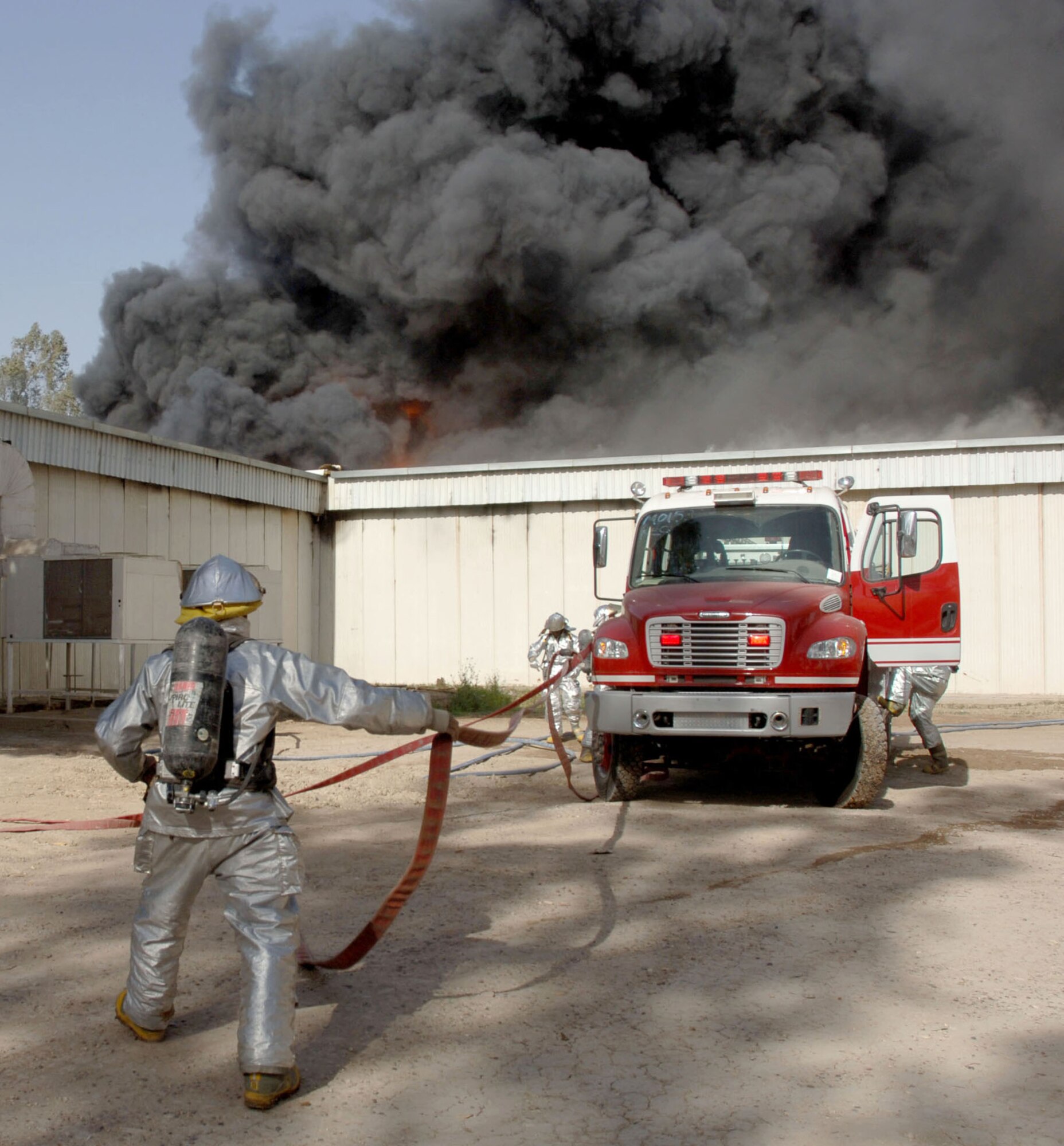 Firefighters from the 447th Expeditionary Civil Engineer Squadron fire department, based at Sather Air Base, Iraq, prepare to battle a five-alarm blaze at a weapons training facility Saturday March 11, 2006, at Victory Base Complex. American and Iraqi firefighters saved half of the facility, including an indoor weapons training range. (U.S. Air Force photo/Master Sgt. Will Ackerman)
