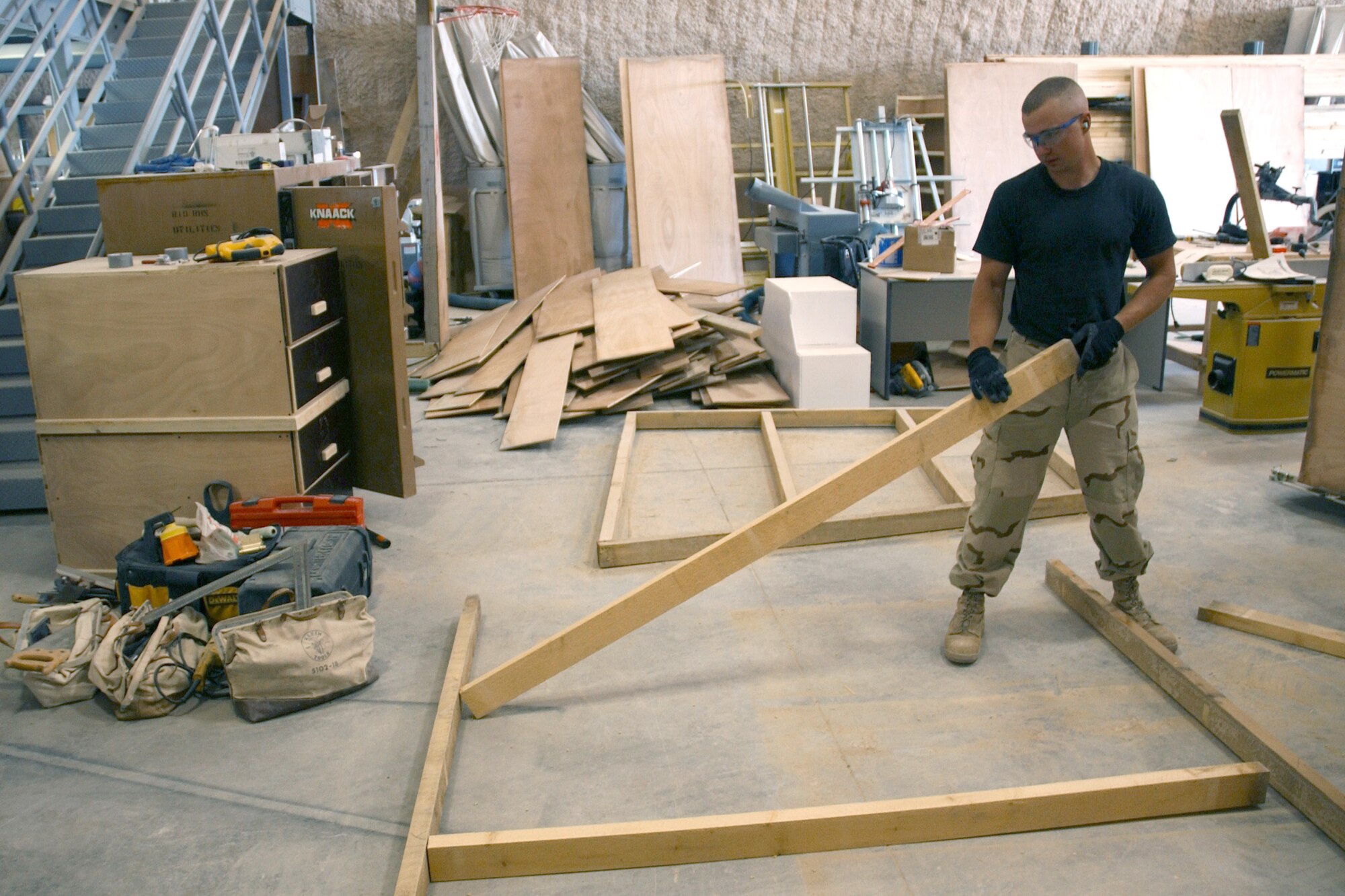 Staff Sgt. Benjamin Jensen builds baggage crates at the passenger terminal at a deployed location in southwest Asia, March 8, 2006. The crates are used to transport the baggage of forward deploying servicemembers. Sergeant Jensen is assigned to the 379th Expeditionary Civil Engineer Squadron. He is deployed from Mountain Home Air Force Base, Idaho. (U.S. Air Force photo/Airman 1st Class Anthony Nelson Jr.)