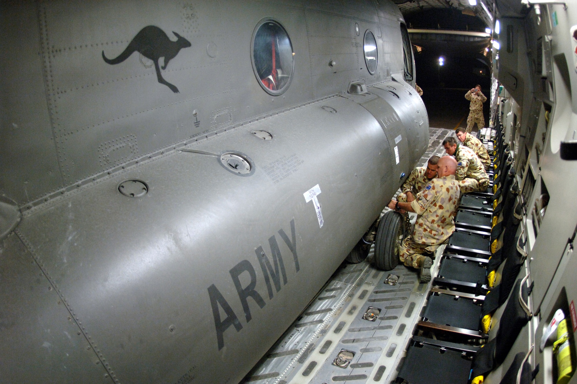 Crewmembers from the 817th Expeditionary Airlift Squadron and their Australian forces counterparts secure an Australian Army CH-47 helicopter onto a C-17 Globemaster III at a deployed location in Southwest Asia on Sunday, Mar 12, 2006. The C-17 is from McChord Air Force Base, Wash. (U.S. Air Force photo/Staff Sgt. Joshua Strang) 
