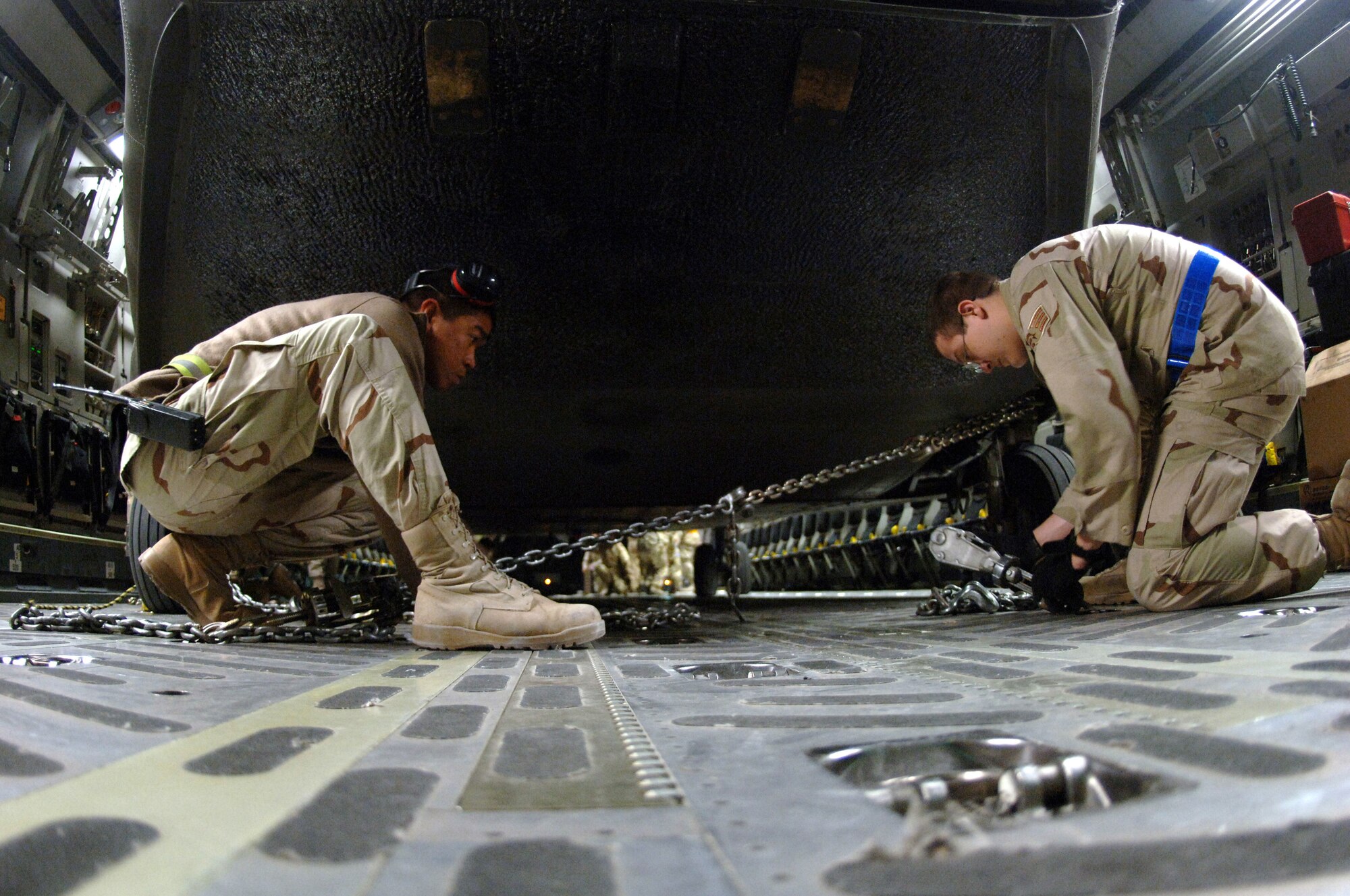 Crewmembers with the 817th Expeditionary Airlift Squadron and their Australian forces counterparts secure an Australian Army CH-47 helicopter onto a C-17 Globemaster III at a deployed location in Southwest Asia on Sunday, March 12, 2006. The C-17 is from McChord Air Force Base, Wash. (U.S. Air Force photo/Staff Sgt. Joshua Strang)