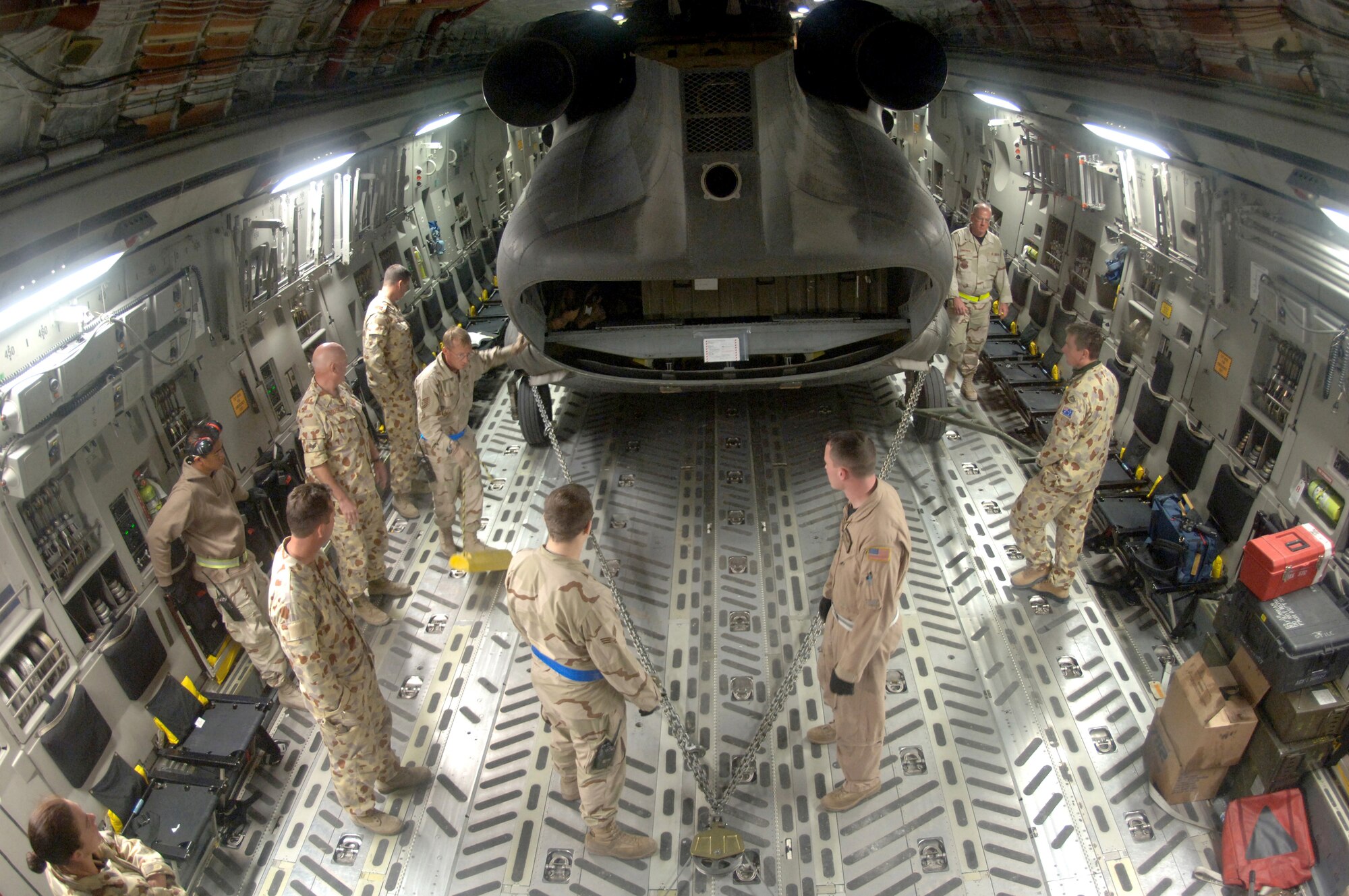 Crewmembers from the 817th Expeditionary Airlift Squadron and their Australian forces counterparts upload an Australian Army CH-47 helicopter onto a C-17 Globemaster III at a deployed location in Southwest Asia on Sunday, Mar. 12, 2006. The C-17 is from McChord Air Force Base, Wash. (U.S. Air Force photo/Staff Sgt. Joshua Strang) 