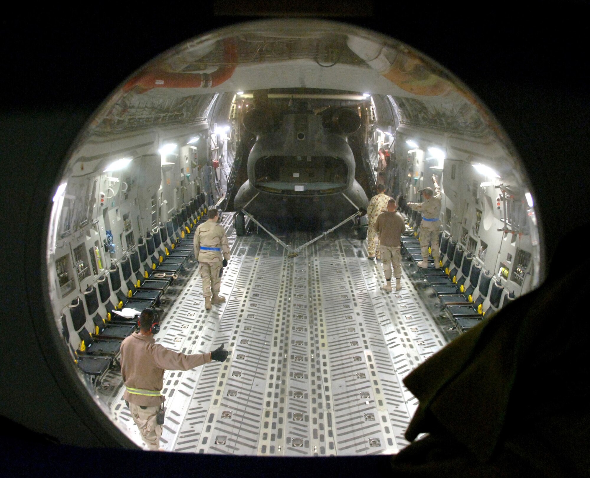 Crewmembers from the 817th Expeditionary Airlift Squadron and their Australian forces counterparts upload an Australian Army CH-47 helicopter onto a C-17 Globemaster III at a deployed location in Southwest Asia on Sunday, Mar. 12, 2006. The C-17 is from McChord Air Force Base, Wash. (U.S. Air Force photo/Staff Sgt. Joshua Strang) 